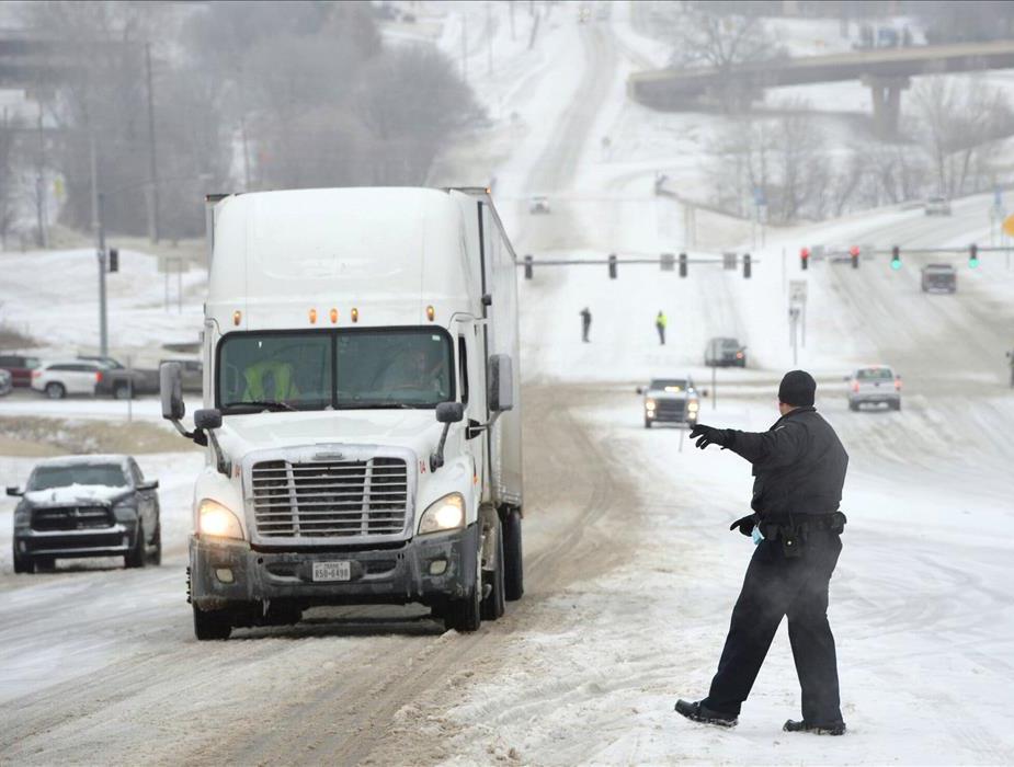 Officer Reroutes Truck in Snow